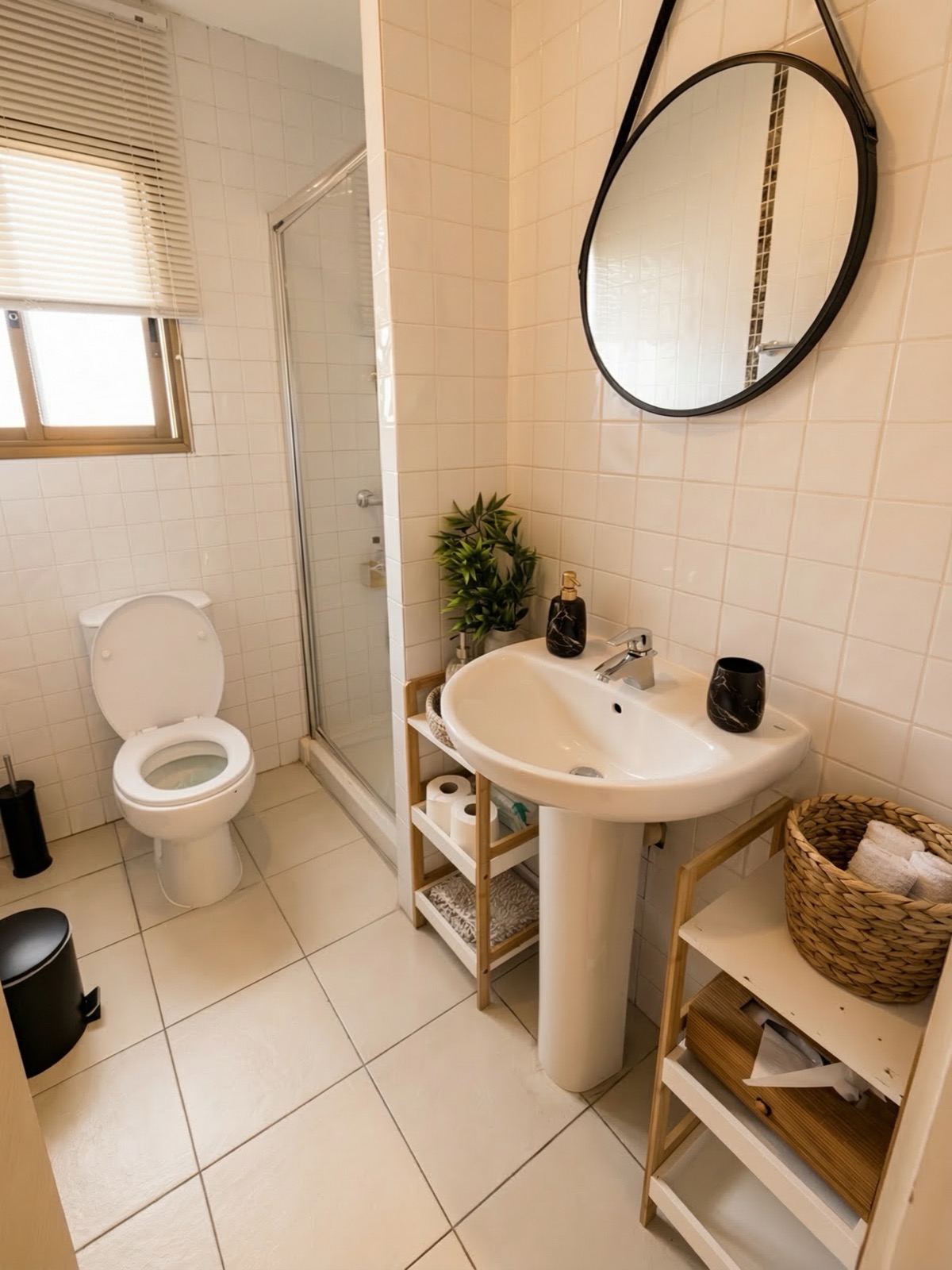 Clean bathroom with shower and round mirror